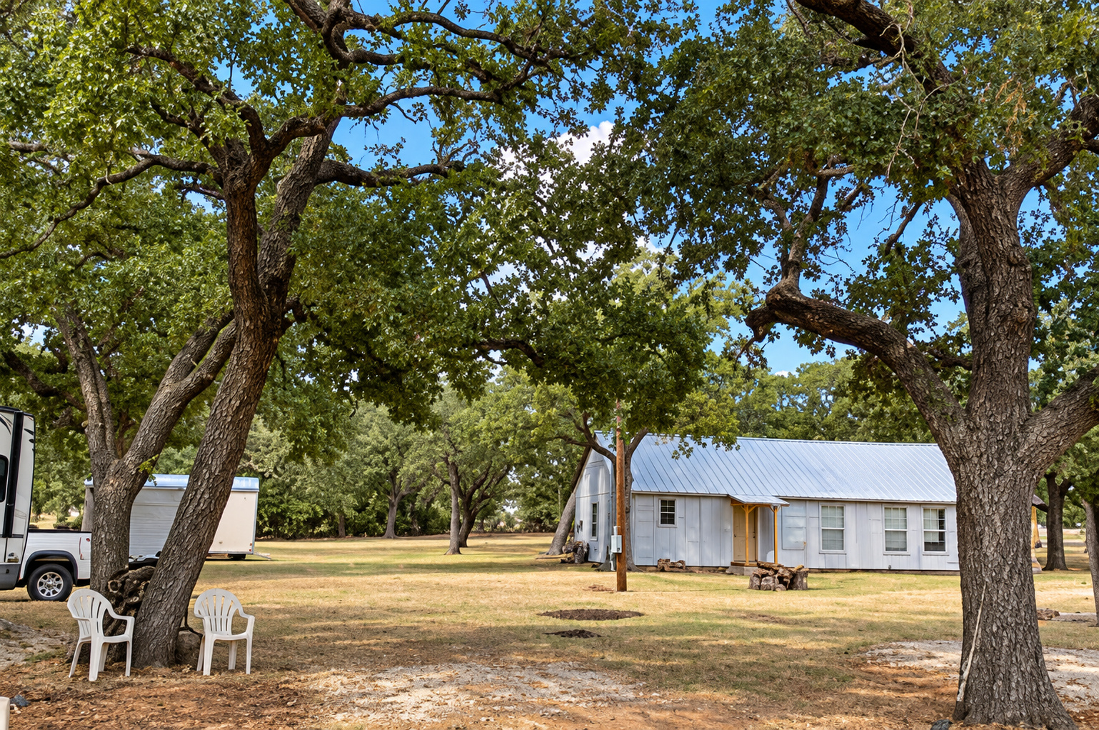 Cabin and shaded grounds beneath mature oak trees at The Oaks at May